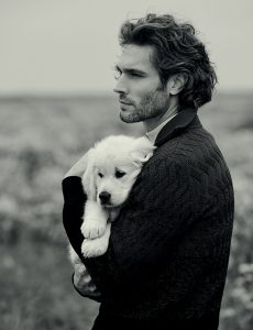 good looking Italian guy with comfortable sweater holding a dog